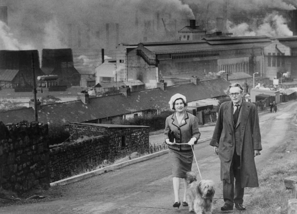 Michael Foot, Labour MP and his wife Jill Craigie photographed in the streets of Ebbw Vale, factories in the background, 1960.