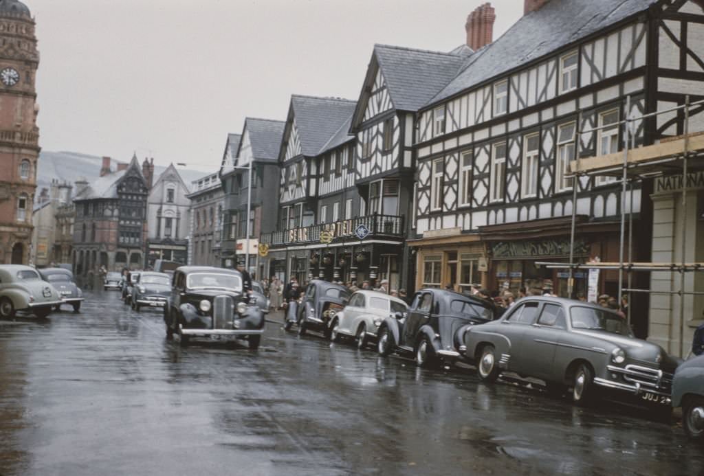 Cars drive down the main street in the market town of Newtown in Montgomeryshire, Wales, 1960.