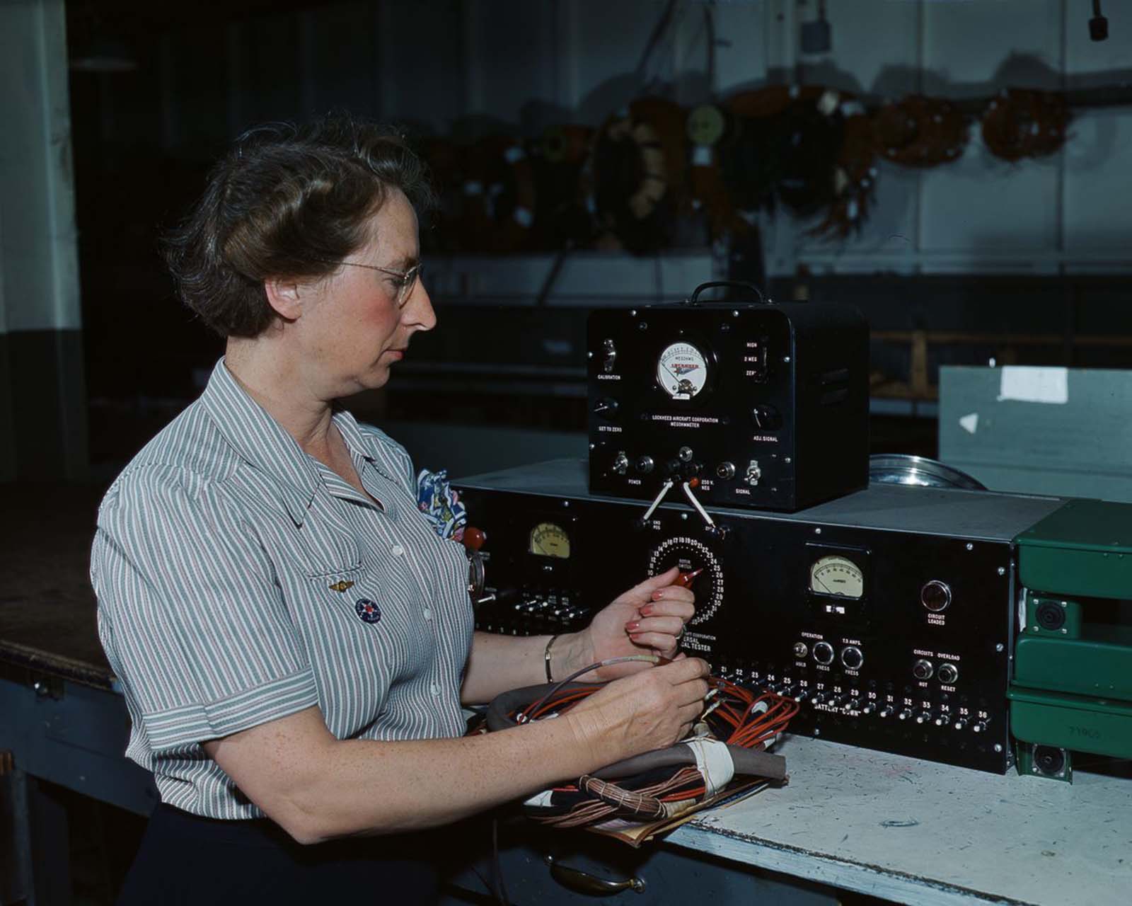 An employee of Douglas Aircraft Company works with electrical wiring at the plant in Long Beach, California, 1942.