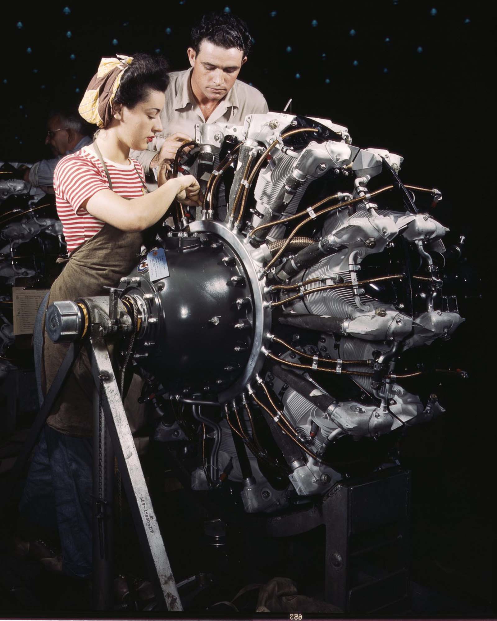 Douglas Aircraft Company employees work on an airplane motor at the plant in Long Beach, California, 1942.