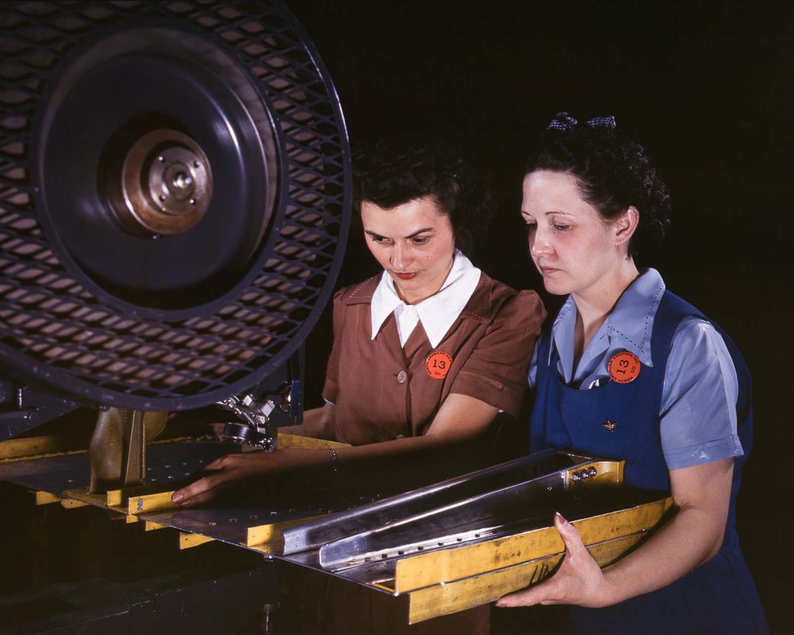 Workers punch rivet holes in a frame member for a B-25 bomber at the North American Aviation plant in Inglewood, California, 1942.