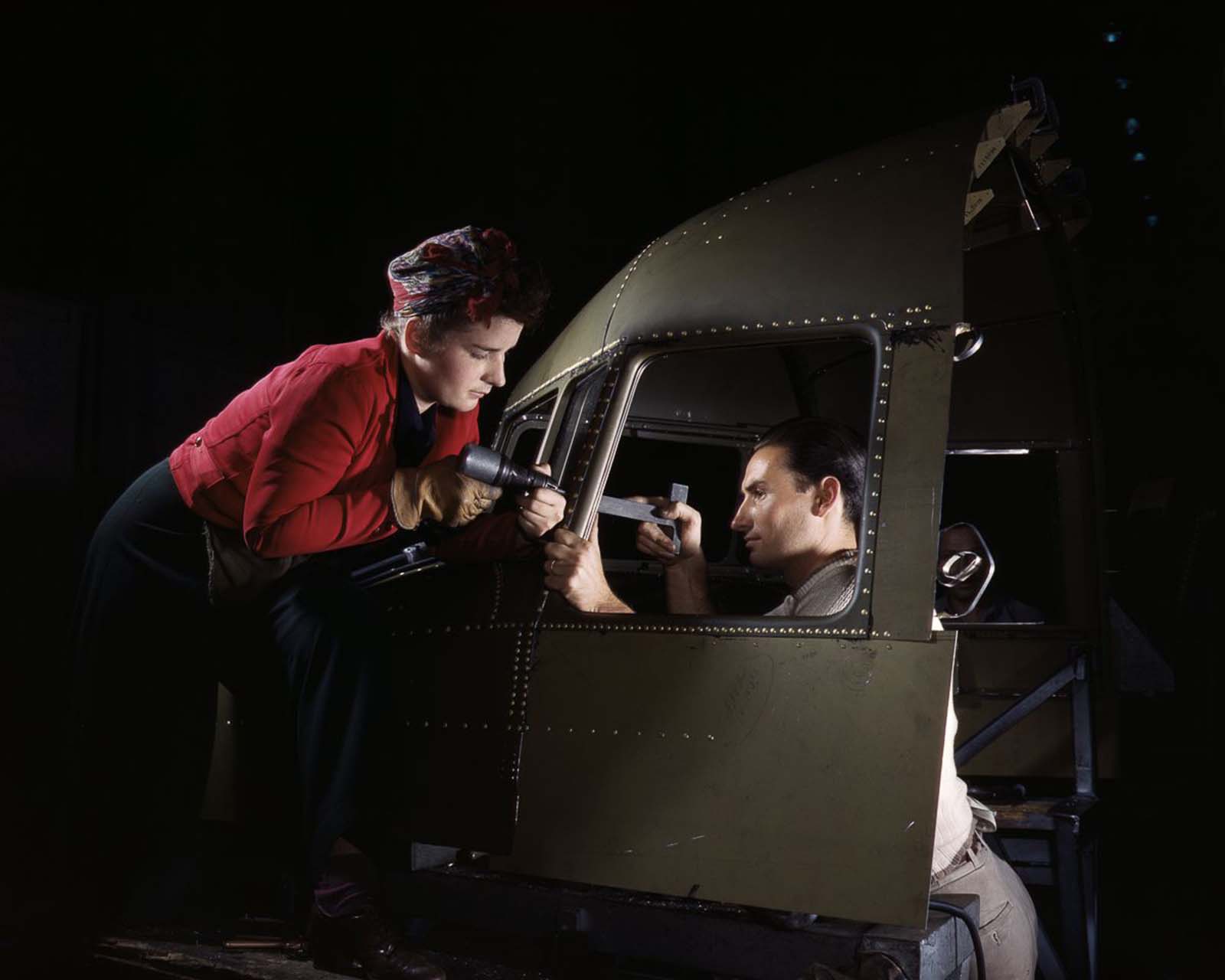 Riveters work on the cockpit shell of a B-25 bomber at the North American Aviation Company plant in Inglewood, California, 1942..
