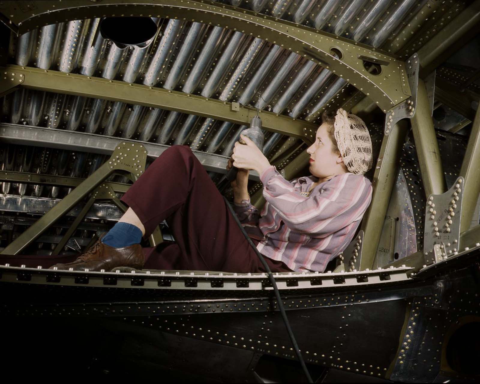 A Douglas Aircraft Company worker rivets an A-20 bomber at the plant in Long Beach, California, 1942.