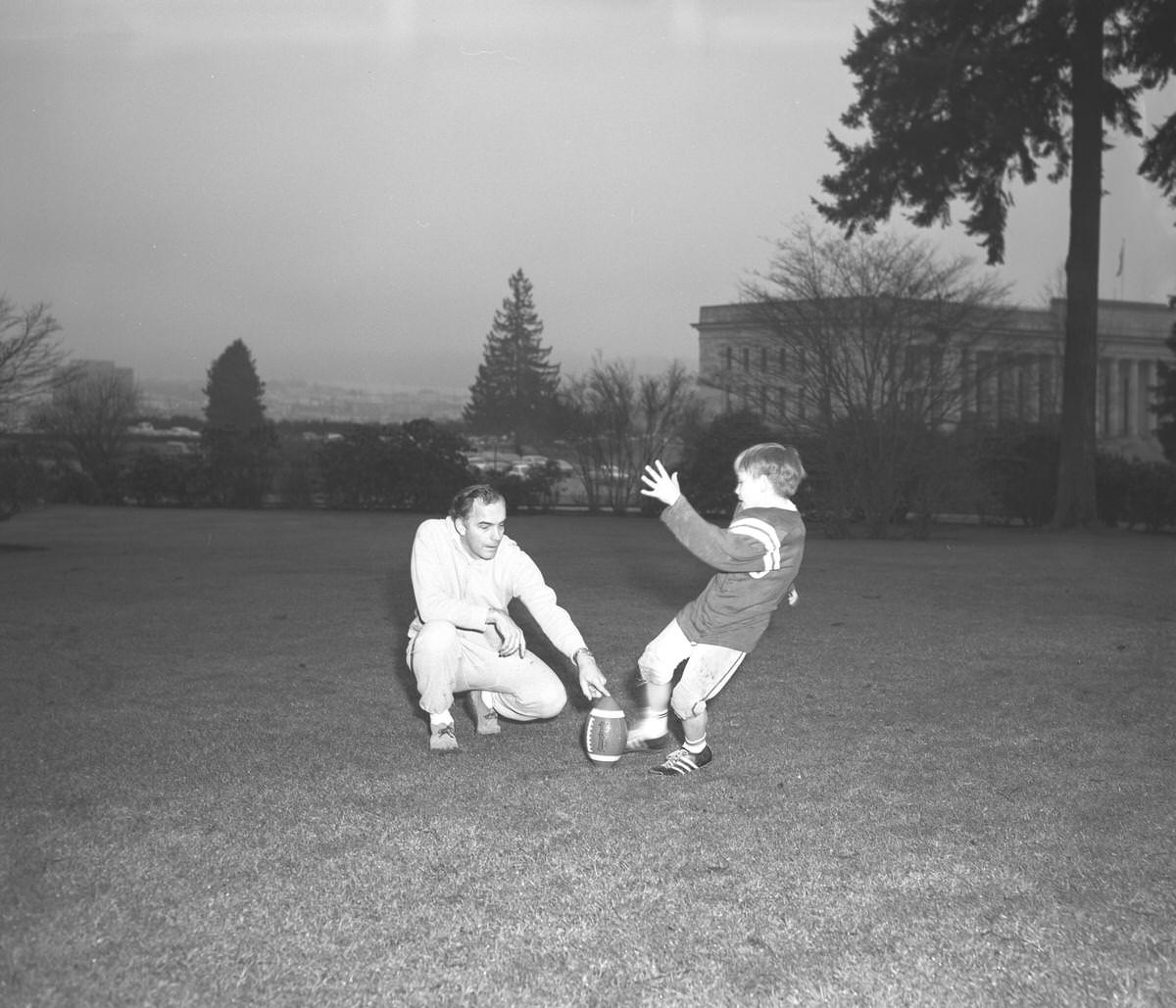 Evans and son playing football, 1969