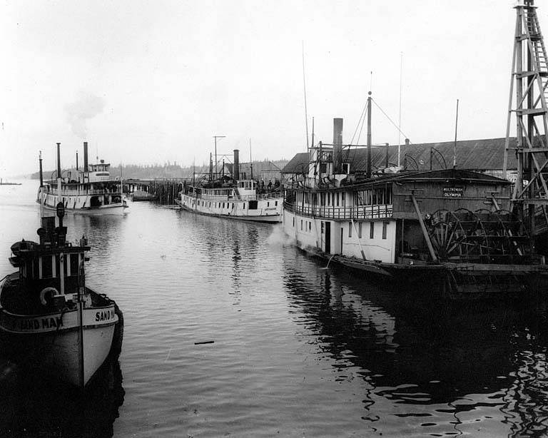 Sternwheel steamers MULTNOMAH, GREYHOUND, and SIMPSON moored at dock in Olympia, with motor tug SAND MAN in foreground, 1911