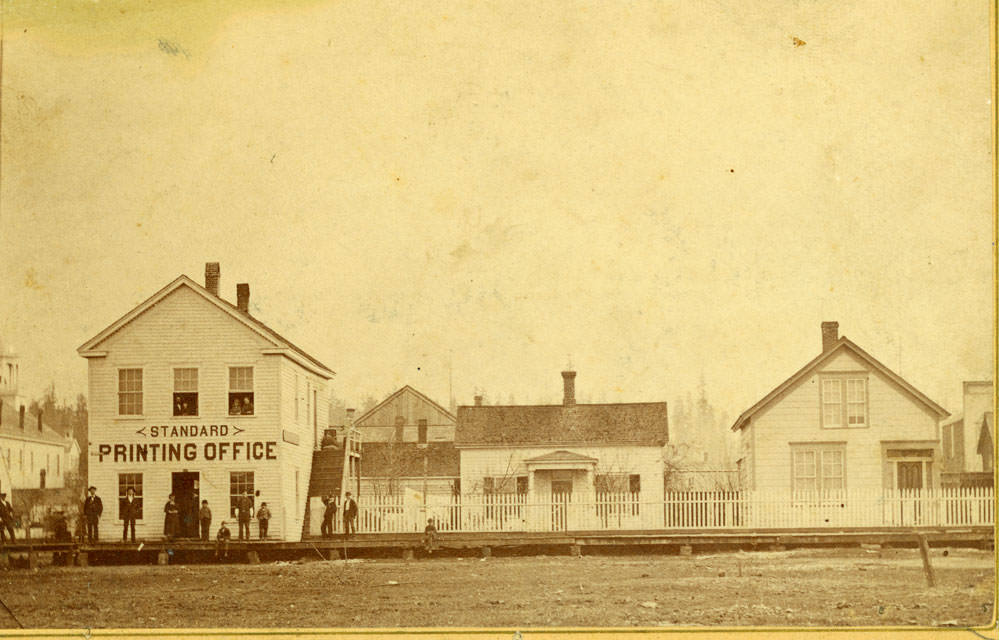 Street with several buildings along a raised sidewalk, Olympia, 1890.