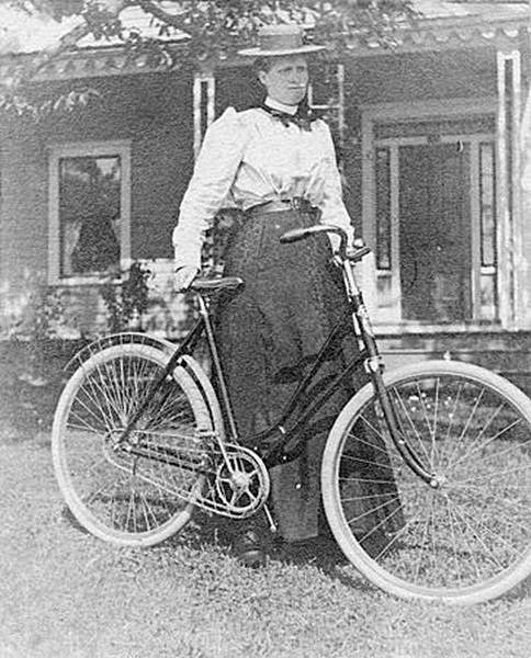 Woman with bicycle at Frost residence, 1890s