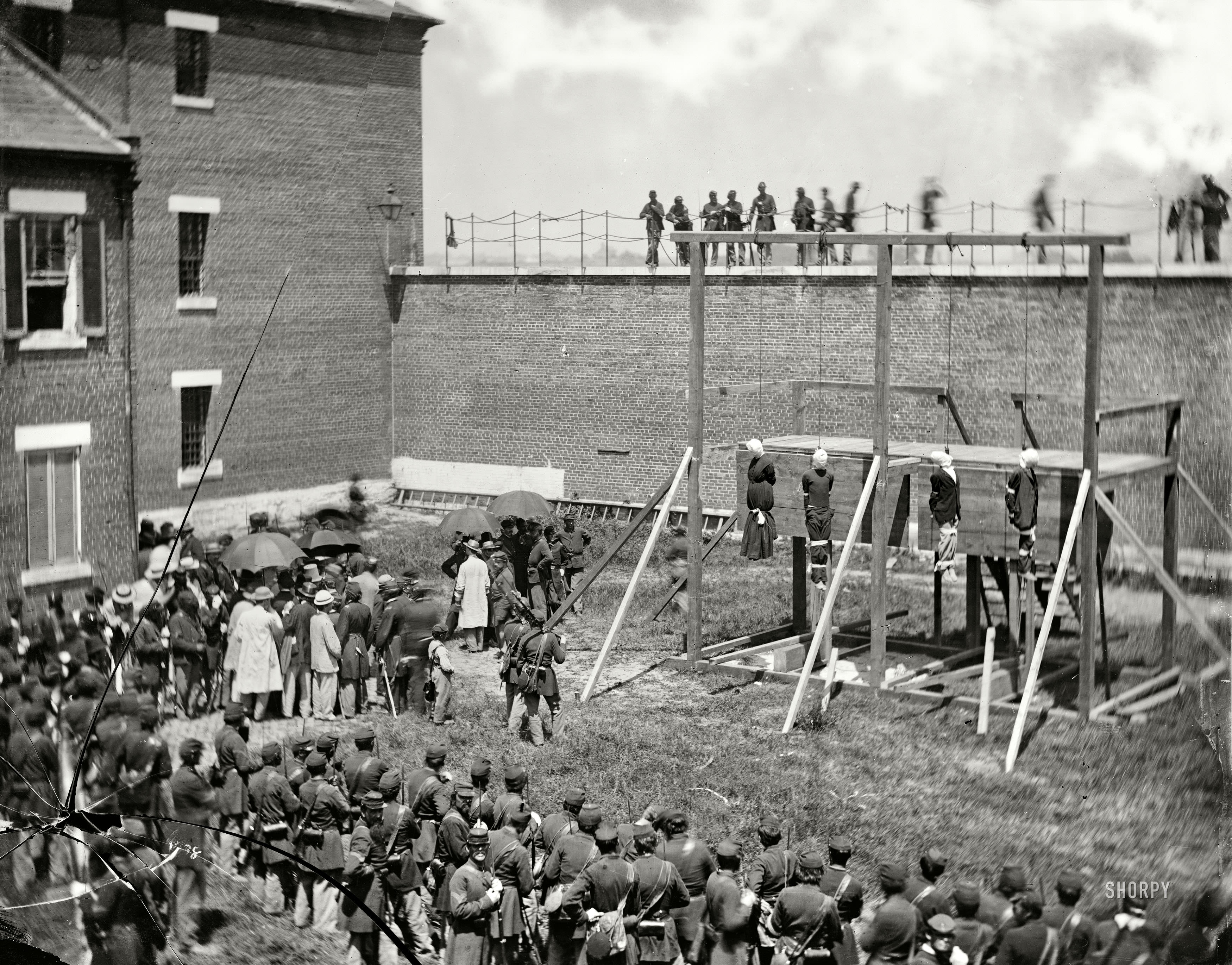 Washington, D.C. Hanging hooded bodies of the four conspirators; crowd departing, July 7, 1865