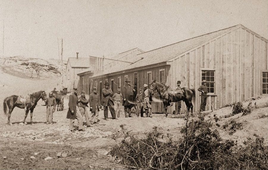 Photographic carte-de-visite of a Civil War scene featuring a view of a Confederate Quartermasters House with a group of officers meeting outside, Washington DC, 1863.