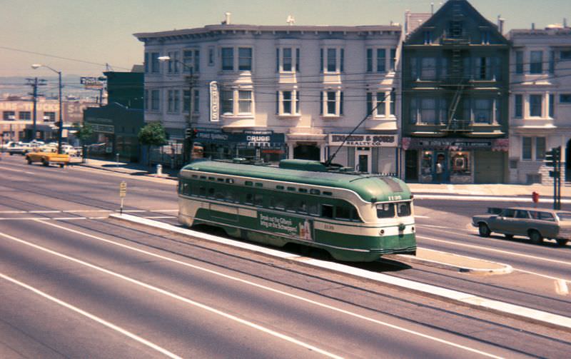PCC heading downtown on Market Street between Noe Street/16th Street and Sanchez Street/15th Street on a foggy early evening, 1970