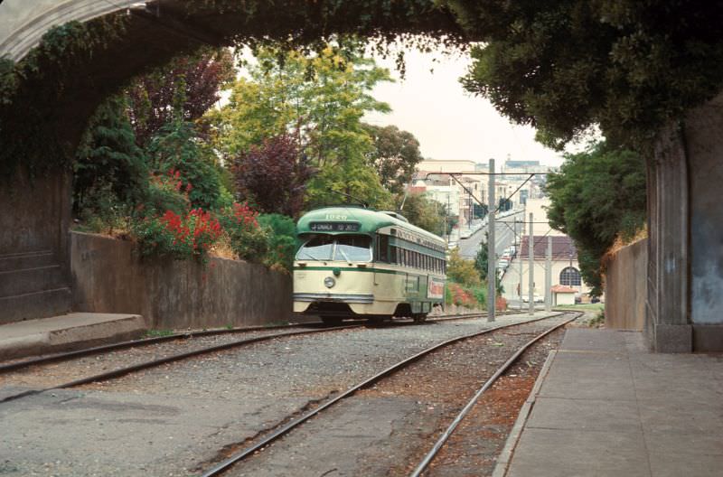 PCC on the J-Line about to pass under the pedestrain walkway in Dolores Park at 19th, 1971