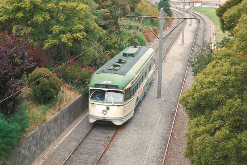 PCC on the J-Line about to pass under the pedestrain walkway in Dolores Park at 19th Street looking north, 1971