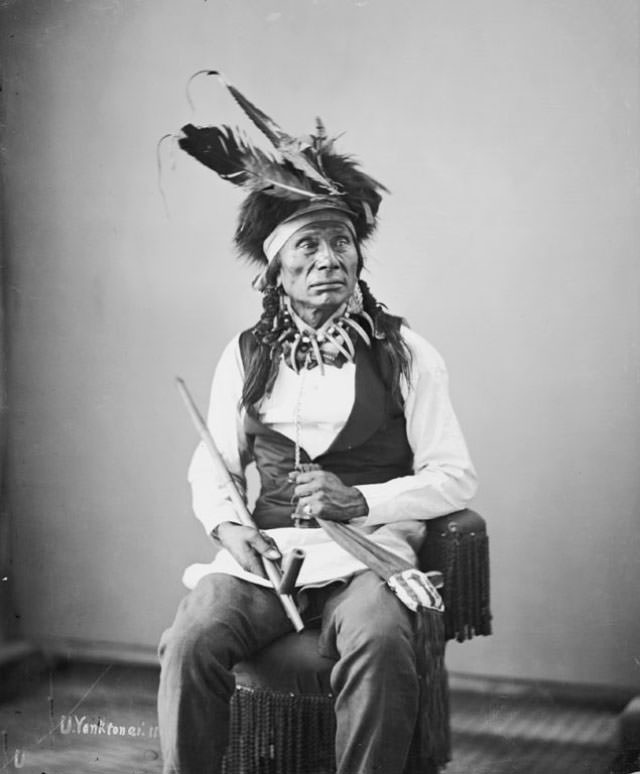 I-Ste-Sa-Pa (Black Eye) holding pipe and beaded bag.