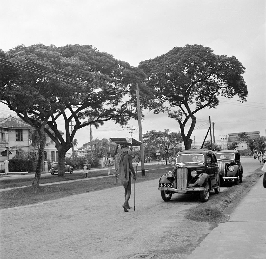 A street view as a local man carries items on his head in Bridgetown, 1946