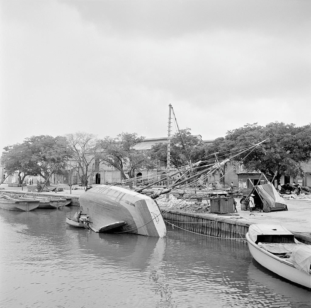A wooden ship listing over in the harbor in Bridgetown, 1946