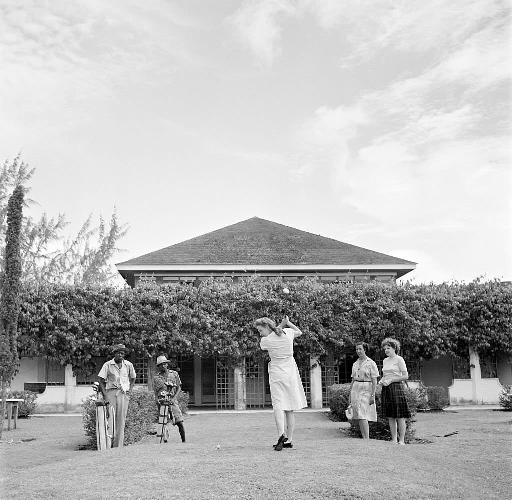 A women tees off at a local golf course in Bridgetown, 1940s