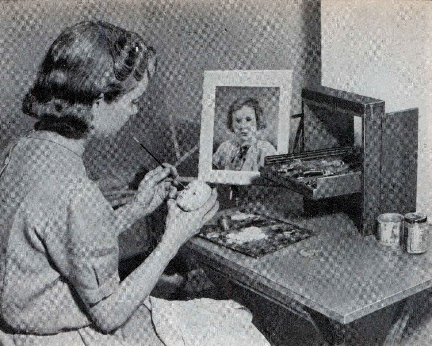 Dewees Cochran painting eyebrows on a doll head modeled from a real child.