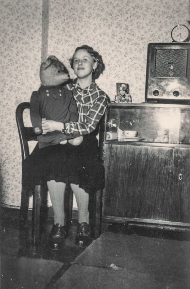 Little girl holding a large teddy bear, 1930s