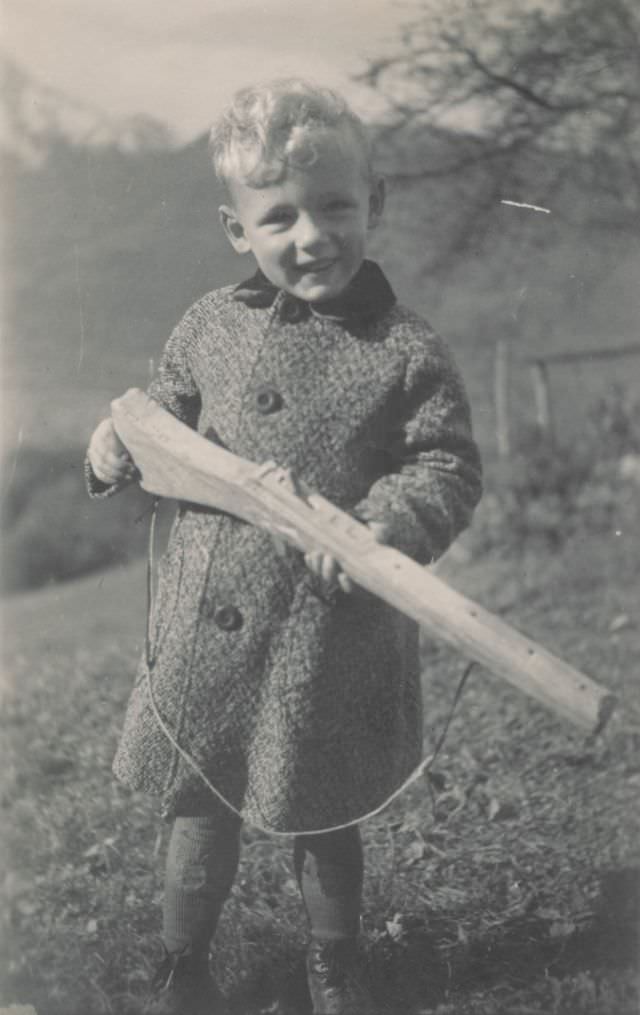 Little boy playing with a toy rifle, September 1944