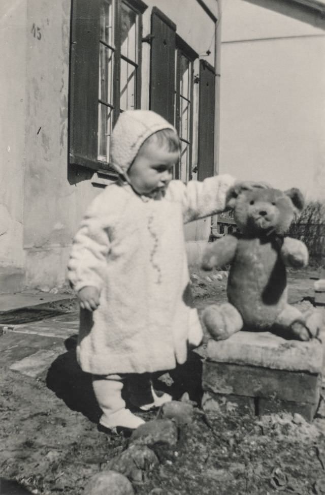 Little baby holds up a stuffed bear, March 23, 1949