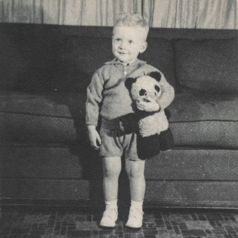 Little boy holds a teddy bear, 1950s