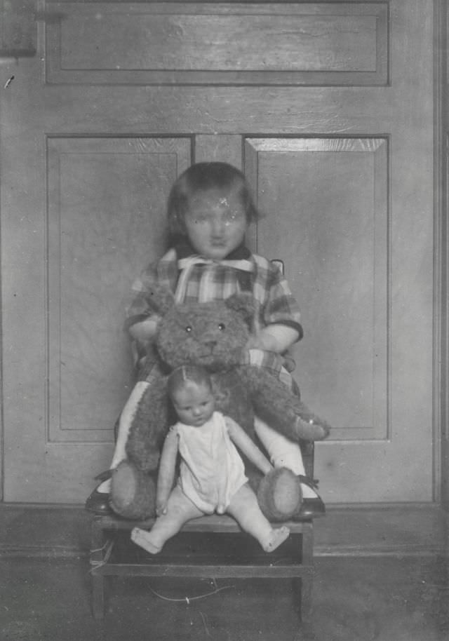 Blurry-faced girl with her doll and stuffed bear