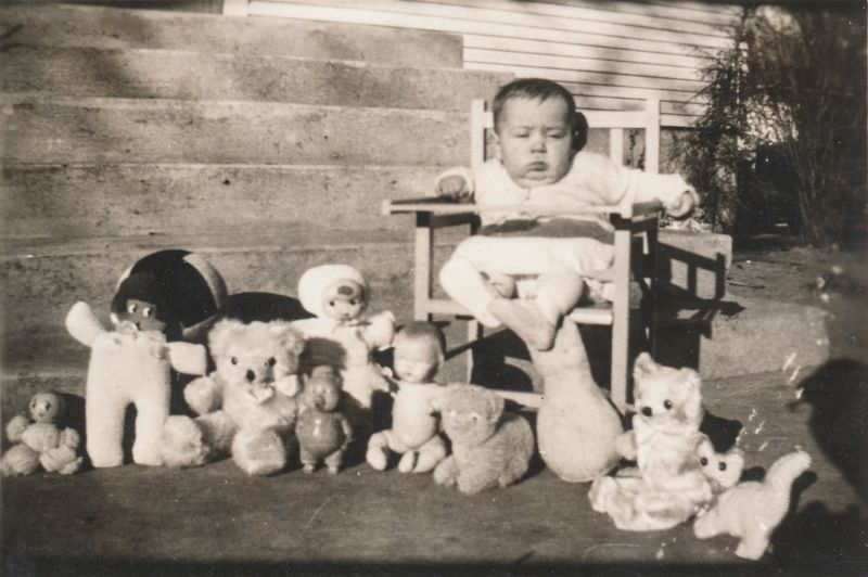 Chubby baby posing with his toys