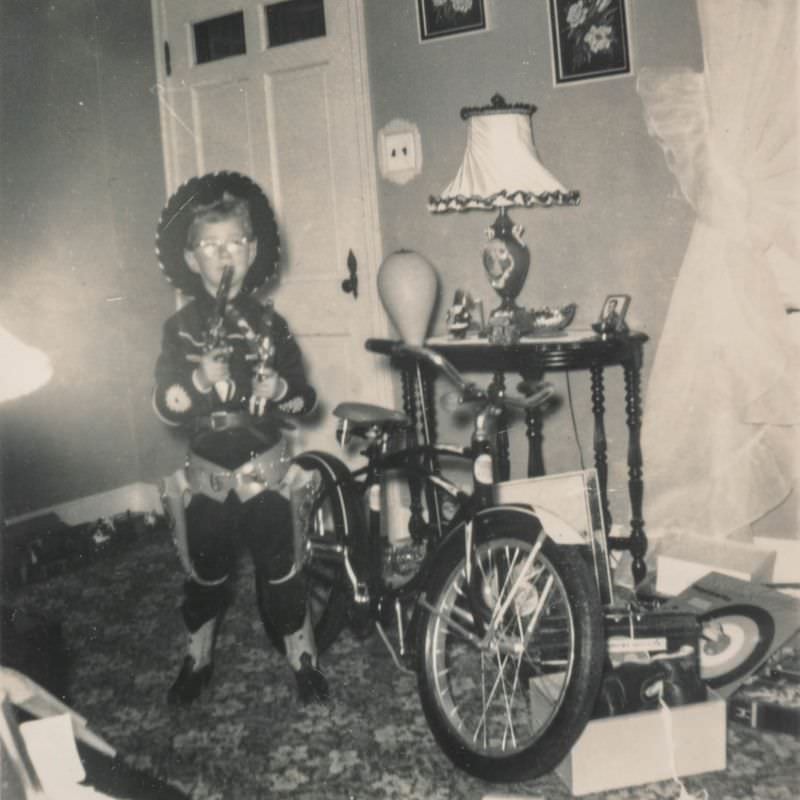 Little boy dressed as a cowboy posing with his new bike