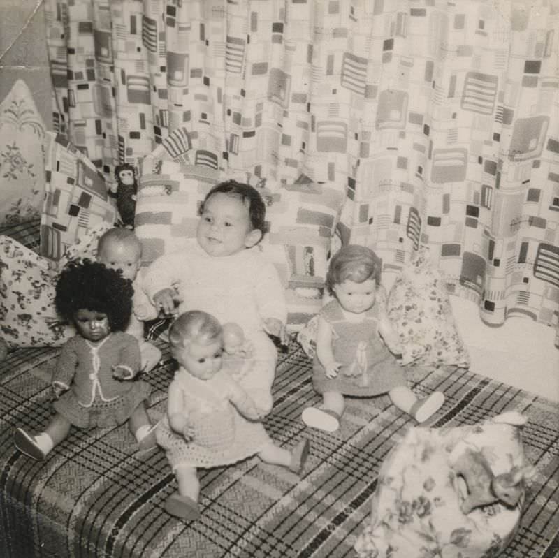 Little girl surrounded by her dolls