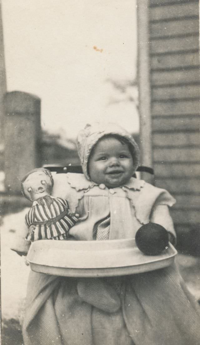 Toddler playing with a stuffed doll and toy