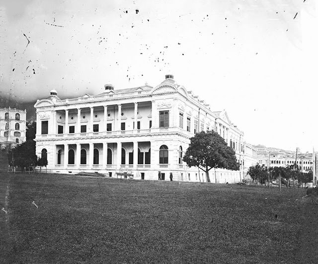 City Hall with two posed Chinese males at the base of the building’s near corner, 1869
