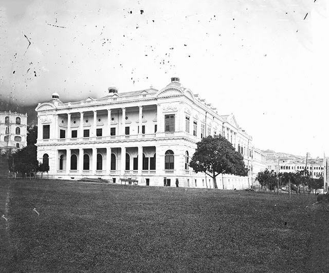 City Hall with two posed Chinese males at the base of the building’s near corner, 1869