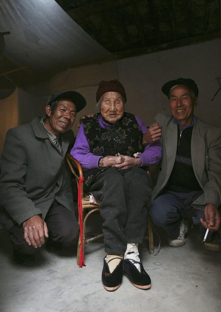 100-year-old bound feet woman, whose surname is Luo Pu, poses for pictures with her son at Liuyi Village on April 3, 2007 in Tonghai County of Yunnan Province, China.