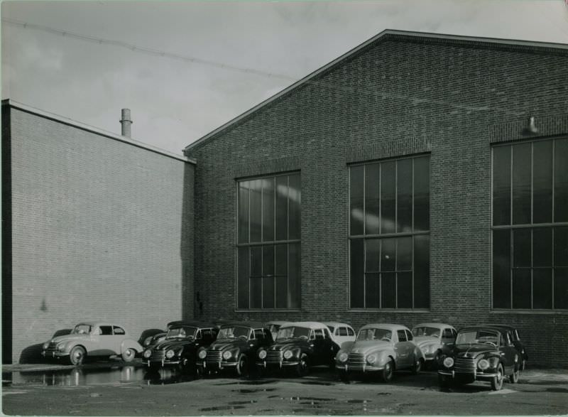 Side of factory building with sedans and cabriolets, 1951