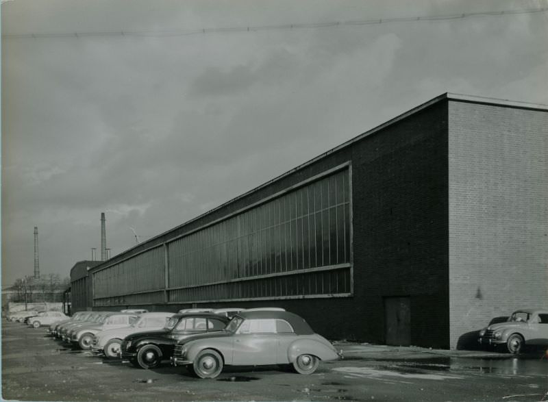 Side of factory building with sedans and cabriolets, 1951