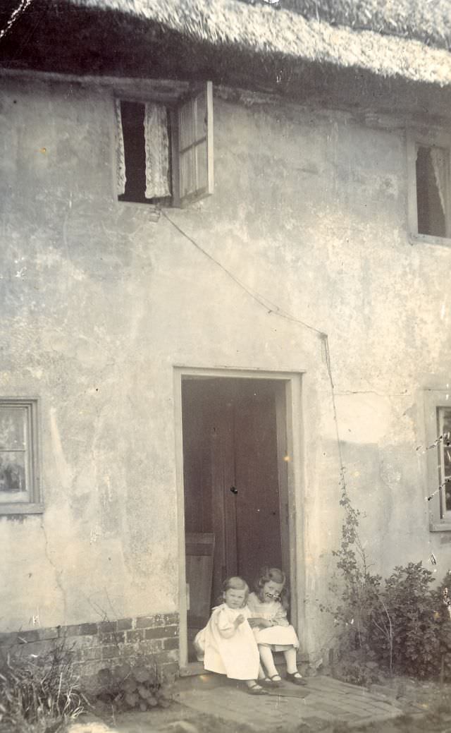 On the door step of a thatched cottage