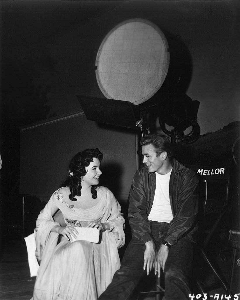 ames Dean and Elizabeth Taylor chat on the set of the Warner Bros film 'Giant' in 1955 in Los Angeles, California.
