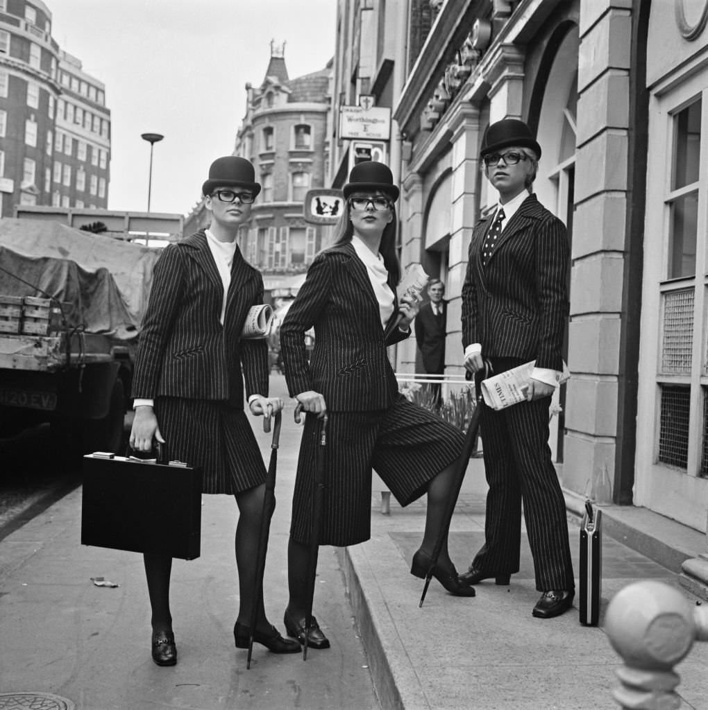 Models Mary Keates (left), Claudia Halle and Michelle Jaques wearing pinstriped business suits with skirts, culottes and trousers.