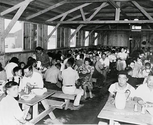 Evacuees enjoying a hearty meal in Center dining hall / U.S. Army Signal Corps.