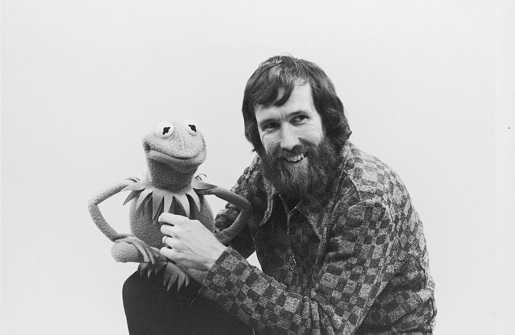 Portrait of American film & televison director and puppeteer Jim Henson (1936 - 1990) as he holds muppet Kermit the Frog, late 1970s or early 1980s.