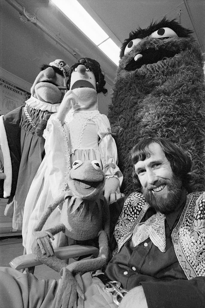 Jim Henson, creator of the merry and memorable Muppet puppets, poses with a few of his creations recently.