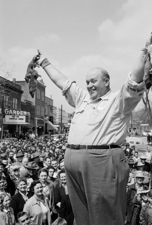 Rat catcher shows his bounty in the town square, Louisa Kentucky, 1953.