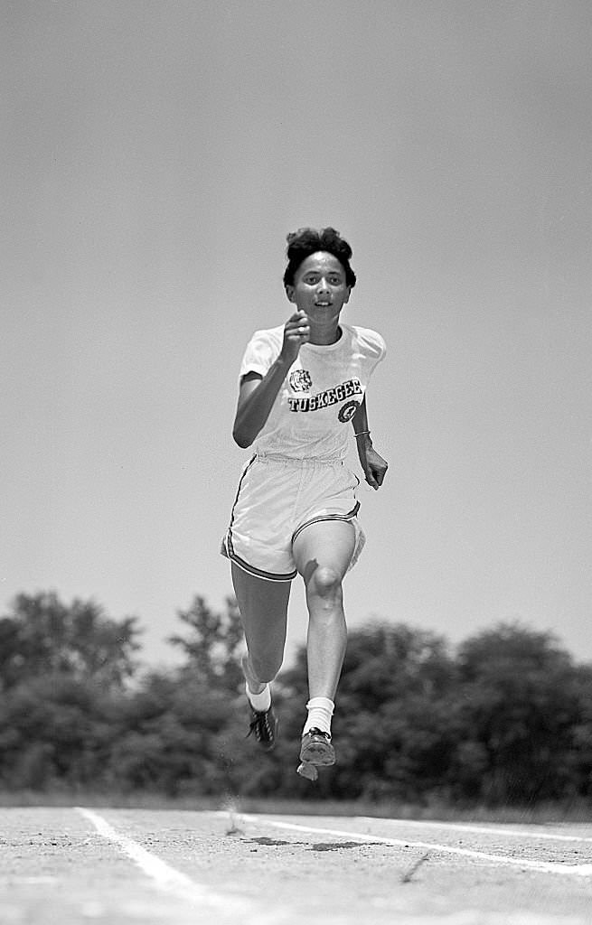 Tuskegee Nell Jackson in action during photo shoot on campus, 1952