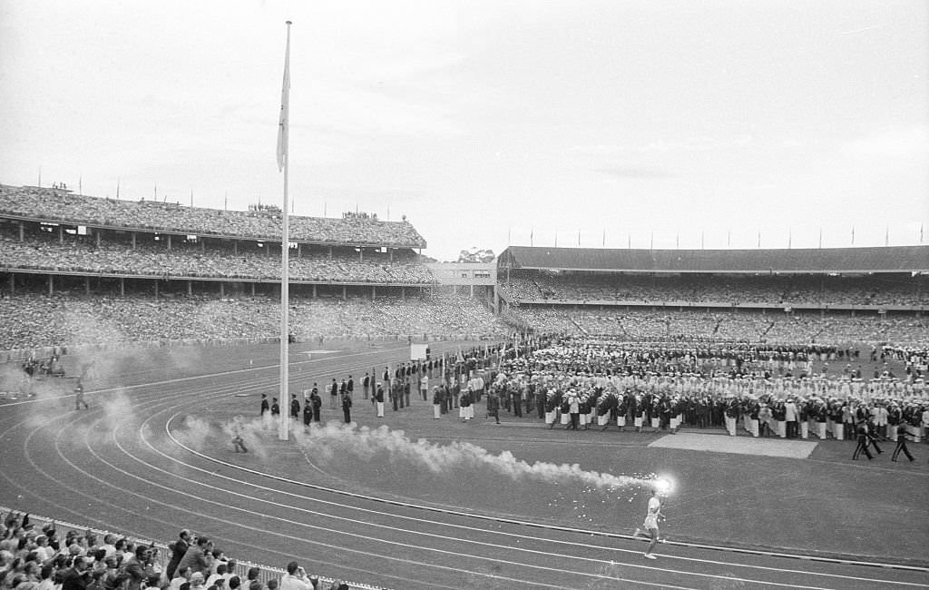 Wide view of Australia Ron Clarke with Olympic torch at Melbourne Cricket Ground Stadium. Melbourne, 1956