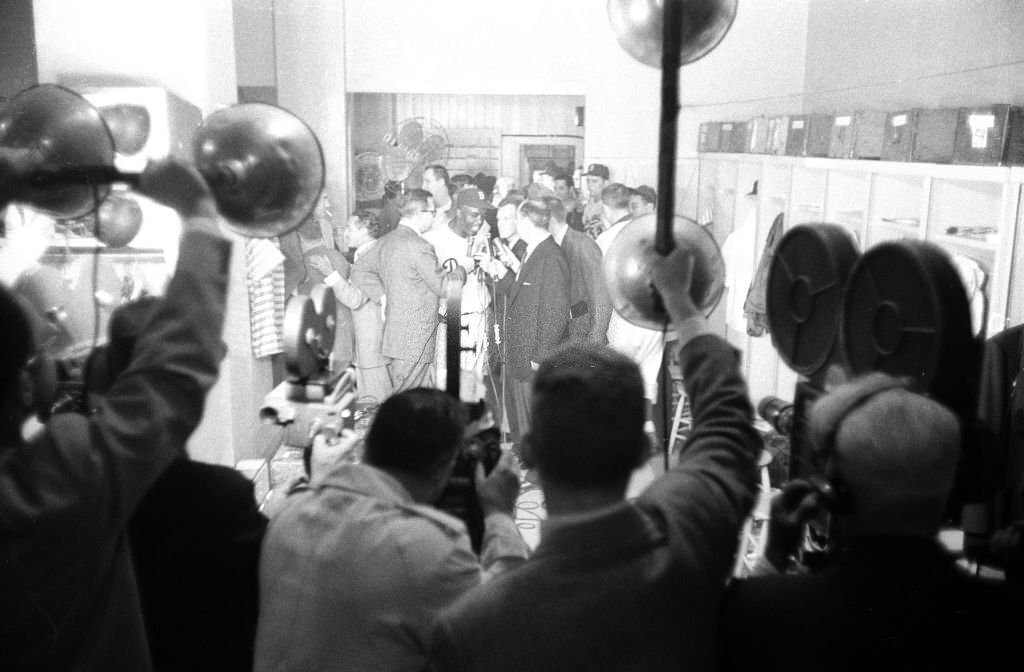 Brooklyn Dodgers Jackie Robinson victorious, speaking with members of the media in clubhouse after winning game to win pennant vs Pittsburgh Pirates at Ebbets Field.