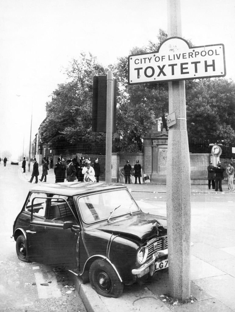 A wrecked car at the Toxteth boundary in Liverpool following riots, July 1981.