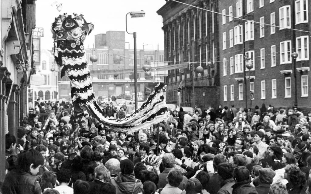 A large crowd watches traditional celebrations for the Chinese New Year, Liverpool, Merseyside, 13th February 1983.