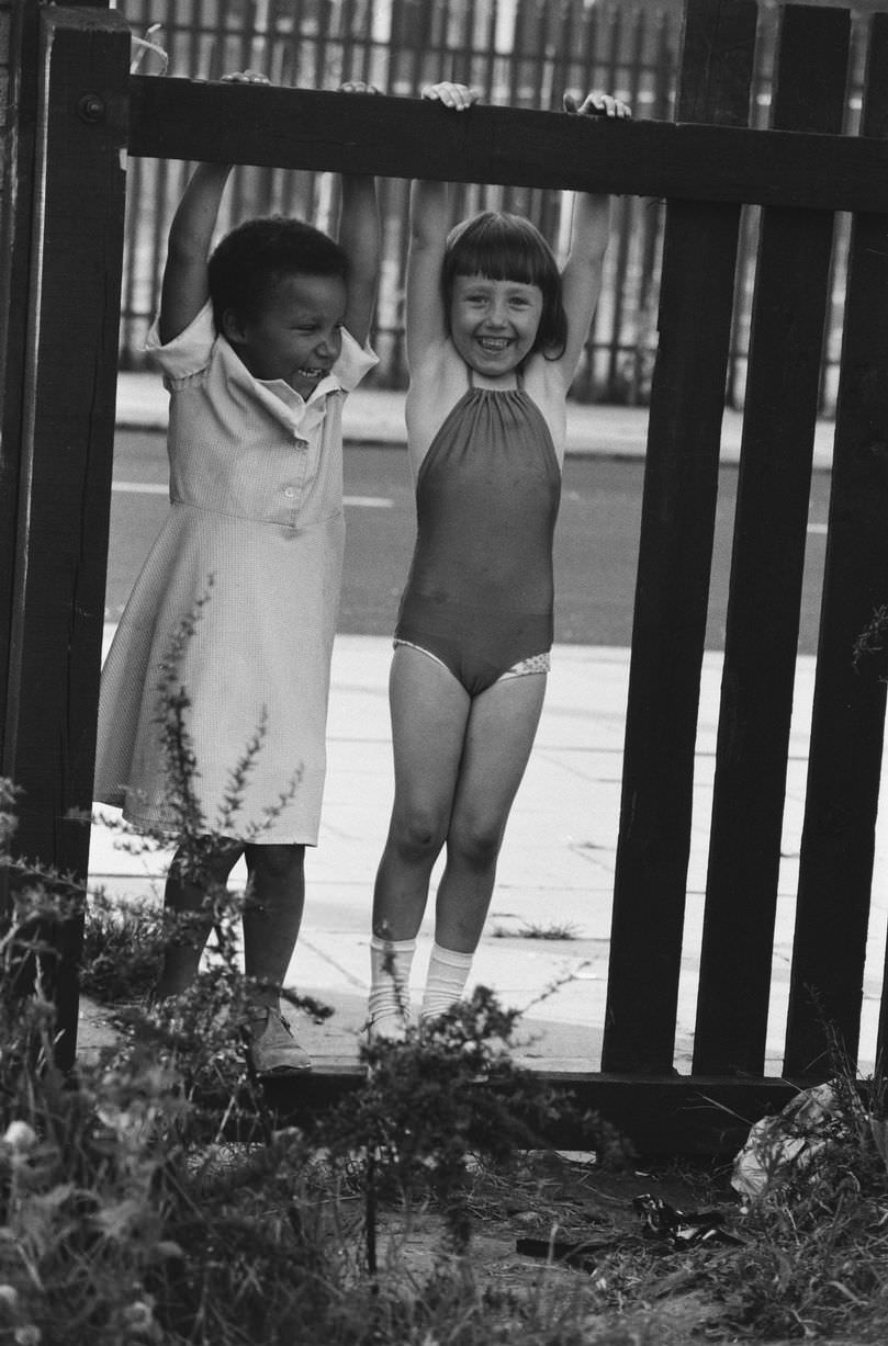 Life in Toxteth. Swinging on the fence are Karen and Buster, 9th July 1981.