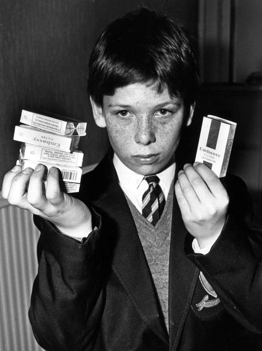 13-year-old Terry Rose with the collection of cigarettes sold to him by shopkeepers in Liverpool, 6th March 1989