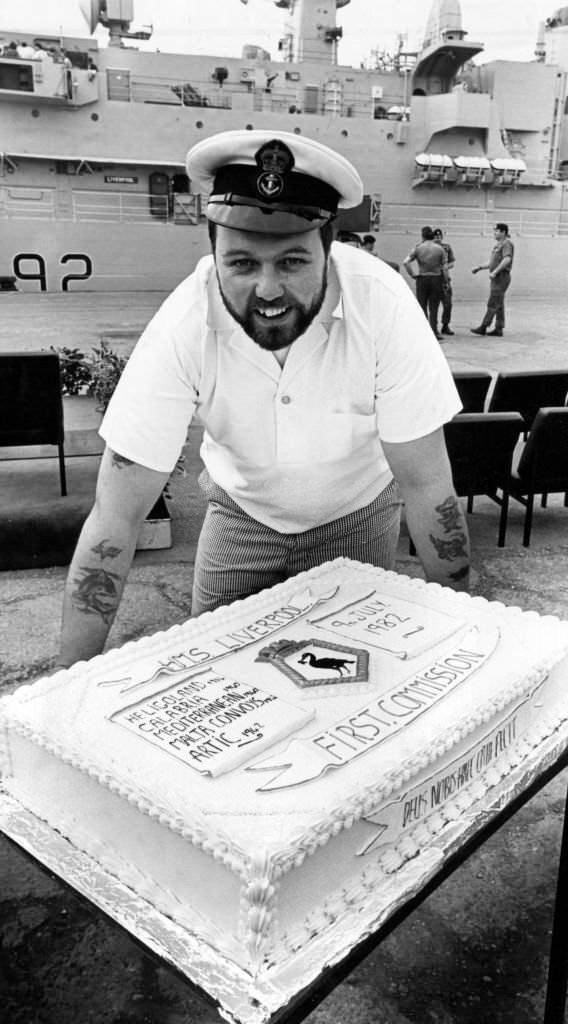 Chef, Petty Officer Bill Colmer with the cake made to commemorate HMS Liverpool's commissioning ceremony, 9th July 1982.